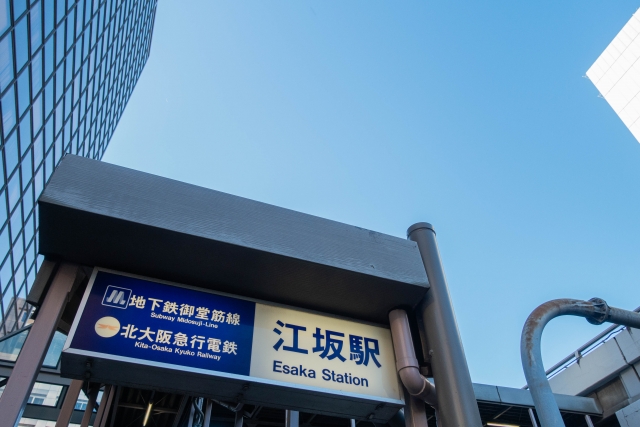 青空のもとにある地下鉄御堂筋線・北大阪急行電鉄の江坂駅看板